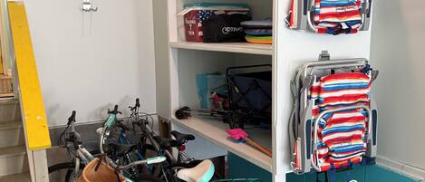 A storage area with shelves holding bags and a bicycle.