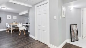 Un interno moderno con zona pranzo, porte bianche e un quadro appeso al muro.
