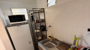 A compact kitchen with a refrigerator, microwave, sink, and a small toaster. - Ezeiza Victoria Barrio Uno, only 5' min from Ezeiza airport. (Ezeiza)