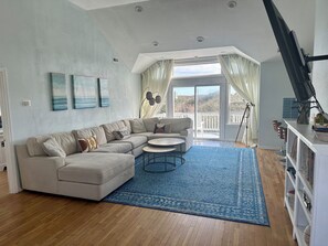 Una sala de estar con un sofá modular, una mesa de centro redonda y un tapete azul.