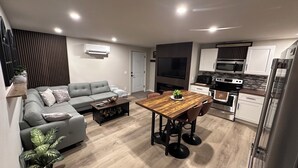 Een modern appartement met een woonkamer, eethoek, keuken en ingebouwde airconditioning.