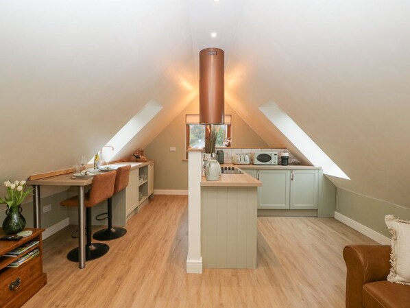 A modern loft apartment with a kitchen, dining area, and a cozy seating space.