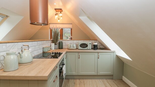 A kitchen with a wooden countertop, a stove, a microwave, and cabinets. - Charming apartment set in the Wye Valley, Herefordshire (Perrystone Hill, Ross-on-Wye)