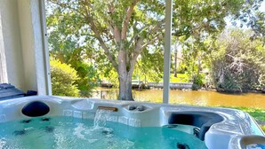 Un bain à remous avec vue sur une rivière et des arbres.