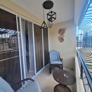 Ein Balkon mit Stuhl, Tisch und einer Zierdeko.