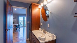 Une salle de bain avec un meuble-lavabo en bois, un grand miroir et un lavabo.