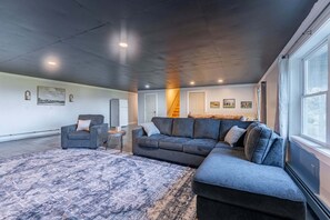 A spacious living room with a large sectional sofa, a small round table, and a patterned rug.