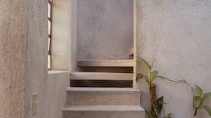 A concrete staircase leading upwards, flanked by walls with a textured finish. - Meridiano 48 Loft, One-Bedroom Accommodation (Mérida)