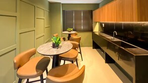A compact kitchen with a dining area, featuring a round table, chairs, and a built-in stove. - Saint Bartz Residence - Ondina (Salvador)