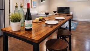 Een moderne keuken met een houten kookeiland, een fles wijn en glazen.