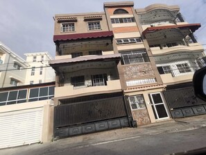 Un immeuble résidentiel à plusieurs étages, doté de balcons, d’une entrée sécurisée et d’un garage.