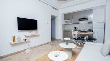 Appartement Confort, salle de bains privée, vue jardin | Coin séjour | Télévision à écran plat de 55 cm avec chaînes par câble