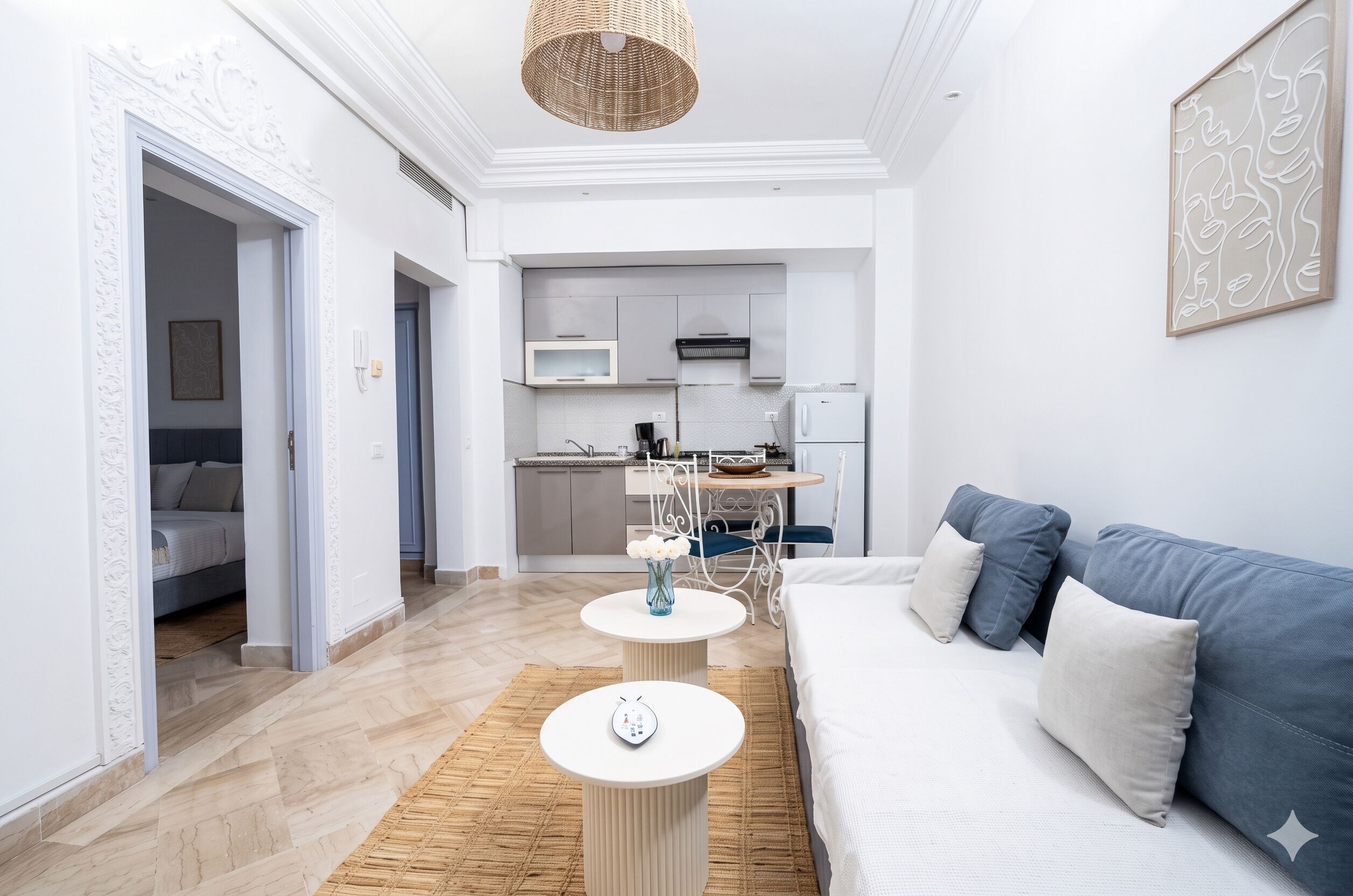 Una sala de estar moderna con un sofá, una mesa de centro y una cocina al fondo.