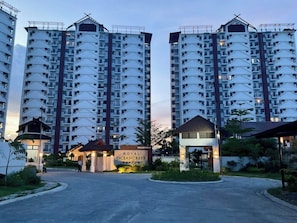 A high-rise residential building with multiple balconies, a gated entrance, and a sign reading 'ROYAL OCEANCREST'. - Delightful 2-bedroom apartment with AC in Lapu-Lapu (Lapu-Lapu)