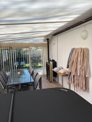 Une chambre moderne avec une table en verre, des chaises, une petite plante, un radiateur et un porte-serviettes.