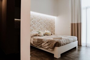 Un dormitorio moderno con una cama, un cabecero estampado y vistas al exterior.