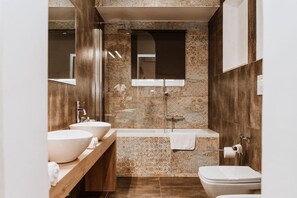 Un baño moderno con dos lavamanos, una bañera y un inodoro.