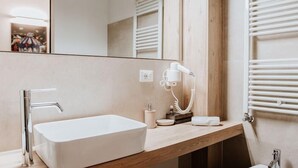 Une salle de bain moderne avec un lavabo rectangulaire, un miroir, une serviette et un sèche-serviettes.