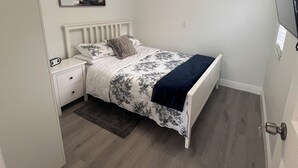 Ein Schlafzimmer mit Bett, Nachttisch, Klimaanlage und Deckenventilator.