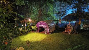 Une tente portant l’inscription « TEMAZCAL » dans un jardin, de nuit.