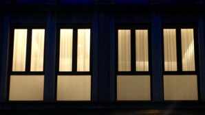A building facade with multiple windows, each with a curtain. - San Felice 135 - 4 (Bologna)