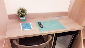 A small wooden desk with a remote control, a potted plant, and a blue mat. - San Felice 135 - 4 (Bologna)