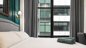 A hotel room with a large bed, a desk, and a window with curtains. - Luxury Fulton Market Condo - Prime Location
Walking distance to Riverwalk (Chicago)