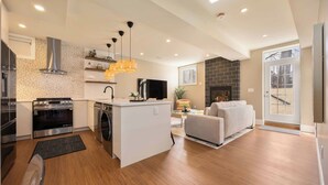 Een moderne keuken met een centraal eiland, een ingebouwde oven en een zithoek met een bank en tafel.