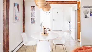 Una cucina moderna con mobili bianchi, un tavolo rotondo e sedie bianche.