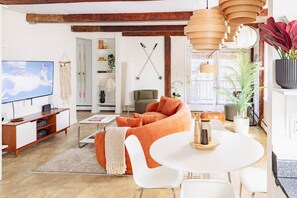 Un salon moderne avec un canapé, un téléviseur et un coin repas.