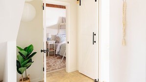 Una stanza con un letto, un tavolino e una pianta.