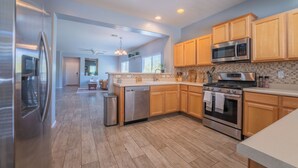 A modern kitchen with stainless steel appliances, wooden cabinets, and a tiled backsplash. - 3-bedroom 2 bath 1 office fully furnished Florence House (Florence)