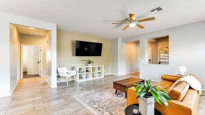 A living room with a TV, sofa, coffee table, and a ceiling fan. - 3-bedroom 2 bath 1 office fully furnished Florence House (Florence)