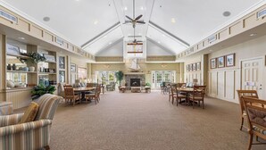 A spacious hotel lobby with high ceilings, a central fireplace, and multiple seating areas. - Bayside Retreat | Luxury Resort w/ Pools/Amenities (Berlin)