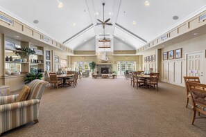A spacious hotel lobby with high ceilings, a central fireplace, and multiple seating areas. - Bayside Retreat | Luxury Resort w/ Pools/Amenities (Berlin)