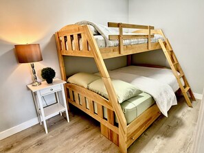 A bunk bed with a desk and lamp, a small plant, and a ladder. - Iron & Oak Suite Minutes from Silverstar Skii Resort  Lakes, Hiking &Restaurant (Vernon)