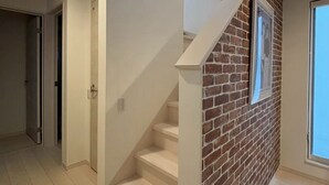 A staircase with white steps leading to a loft area with a skylight. - Entire House on a Hilltop with Panoramic Views of Fukuoka | 92 ㎡ | A Base for Exploring Fukuoka | Sleeps 8, 2 Parking Spaces (福岡市)