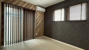 A room with a wooden floor, a ceiling fan, a window with blinds, and an air conditioning unit. - Entire House on a Hilltop with Panoramic Views of Fukuoka | 92 ㎡ | A Base for Exploring Fukuoka | Sleeps 8, 2 Parking Spaces (福岡市)