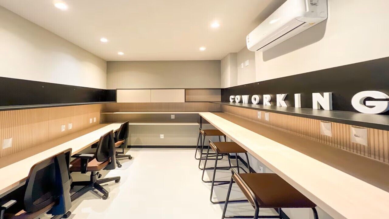 Ein Konferenzraum mit langen Tischen, Stühlen und einem Schild mit der Aufschrift 'Coworking'.
