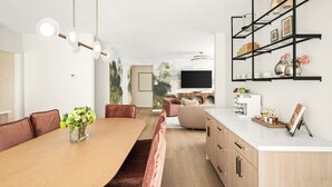 A modern kitchen with a white countertop, wooden cabinets, and a black metal shelf unit. - Resort-Style • 4BR • Heated Pool/Spa • Makeup Room (Houston)