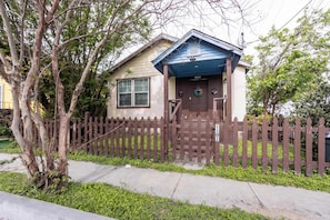 A residential house with a brown picket fence, a front door, and a small porch. - Modern NOLA House with Yard, Your Mardi Gras Base (New Orleans)
