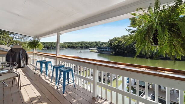 A covered deck with a view of a river, outdoor seating, and a grill. - Lake Front |Private Dock |Blue Bungalow|3bed|2bth (Linn Creek)