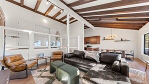 A modern living room with a leather sofa, ottomans, and a dining area with a table and chairs. - Lake View 3BR/2BA in Incline Village, Fireplace (Incline Village)