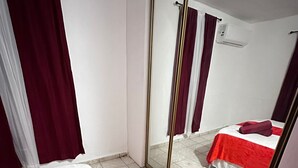 Habitación de hotel con cama, un espejo grande y una toalla roja en el suelo.