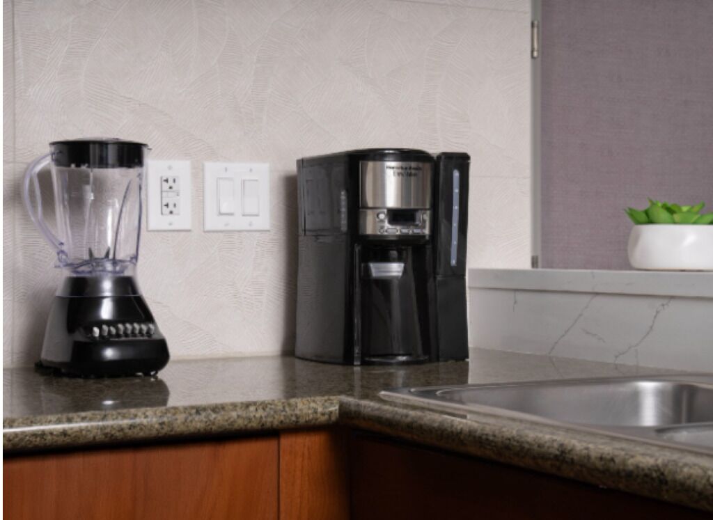 Eine Küche mit Mixer, Kaffeemaschine und Spüle.