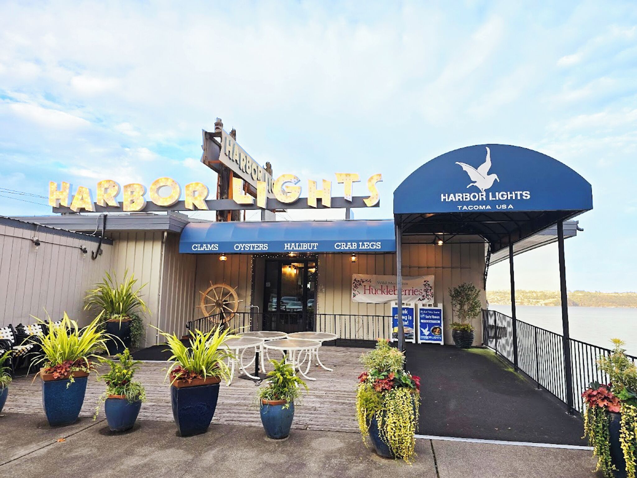 Ein Restaurant namens Harbor Lights am Wasserufer mit Außenbereich und Blumentöpfen.