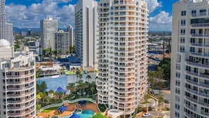 A high-rise hotel with multiple balconies, a swimming pool, and a landscaped area. - Moroccan Surfers - 3BR Apartment (Surfers Paradise)