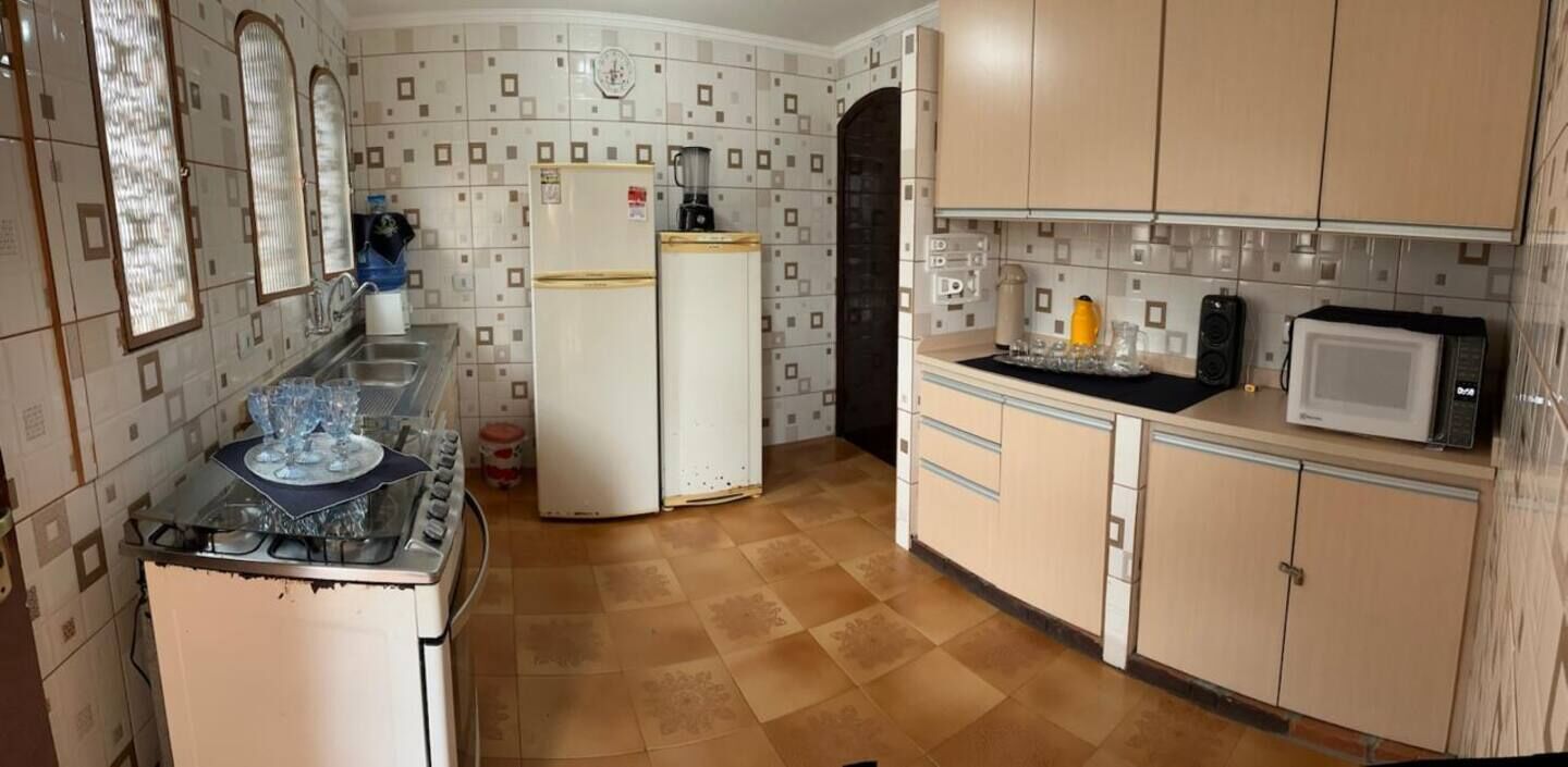 A kitchen with a stove, refrigerator, microwave, and cabinets.