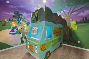 Un mural con un vehículo verde identificado como 'THE MYSTERY MACHINE' y varios personajes.
