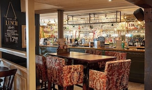 A restaurant with a bar area, patterned chairs, and a menu board. - Spy Glass & Kettle Hotel (Bournemouth)
